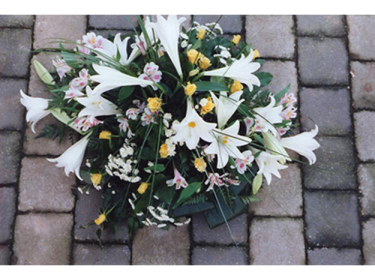Rond bloemstuk met witte, gele en lichtroze bloemen
