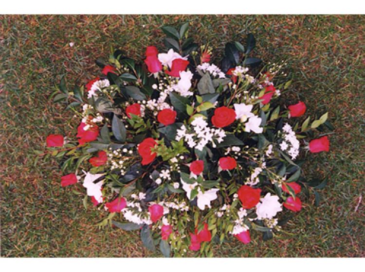 Rond bloemstuk met rode rozen witte bloemen en groen