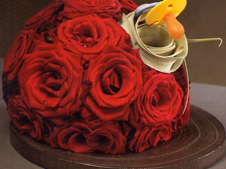 Bloemstuk met rode rozen en een fopspeen